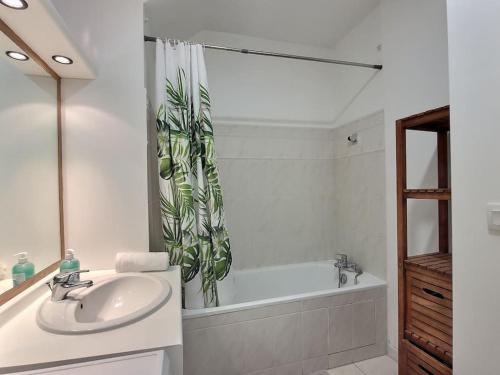 une salle de bain avec un lavabo et une baignoire dans l'établissement Le Cocon de la Garonne*Disney*Val D'Europe*Paris*, à Serris