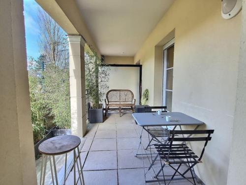 un patio avec des chaises, une table et un banc dans l'établissement Le Cocon de la Garonne*Disney*Val D'Europe*Paris*, à Serris