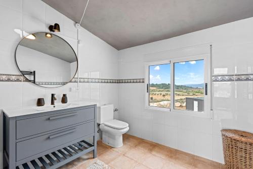 Un baño blanco con lavabo y espejo. en Beautiful finca with private pool near Jumilla, en La Zarza