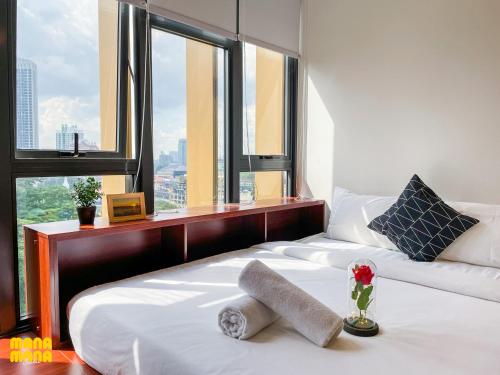 1 dormitorio con 1 cama blanca grande y ventana en Ceylonz Leisure Suites KLCC, en Kuala Lumpur