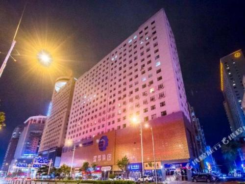 a large building is lit up at night at James Joyce Coffetel Changchun People's Square in Changchun