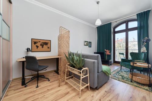 a living room with a couch and a desk and chairs at Apartament SZEPT Galeria Dominikańska by Renters in Wrocław