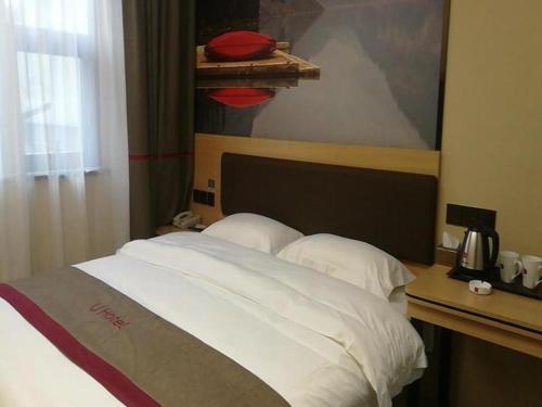 a bed in a hotel room with avertisement at Thank Inn Hotel Sichuan Nanchong Gaoping District Longmen 