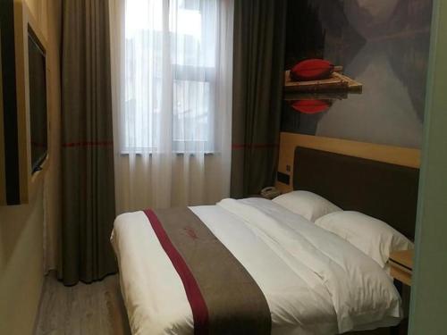 Bett in einem Hotelzimmer mit Fenster in der Unterkunft Thank Inn Hotel Sichuan Nanchong Gaoping District Longmen 