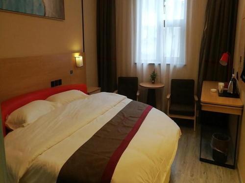 ein Hotelzimmer mit einem großen Bett und einem Schreibtisch in der Unterkunft Thank Inn Hotel Sichuan Nanchong Gaoping District Longmen 