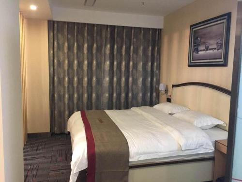 - une chambre avec un grand lit et une fenêtre dans l'établissement Thank Inn Hotel Liaoning Dandong Kuandian County Huaboshan Road, à Kuandian