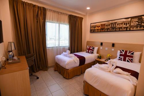 a hotel room with two beds and a desk at hotel bintang in Kuala Lumpur