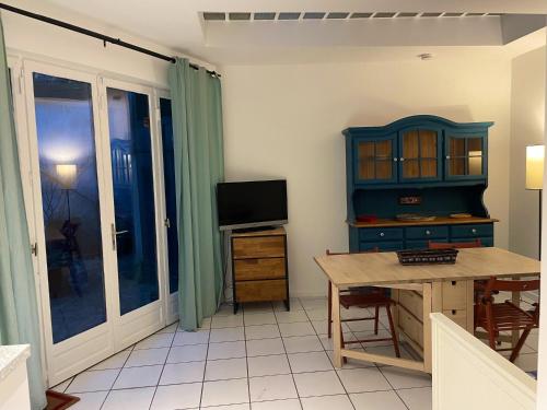 a living room with a desk and a tv at T2 sur cour au coeur des JO 2024 in Saint-Denis
