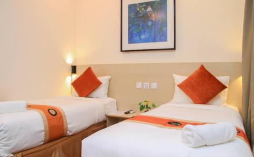 a hotel room with two beds with orange pillows at hotel bintang in Kuala Lumpur