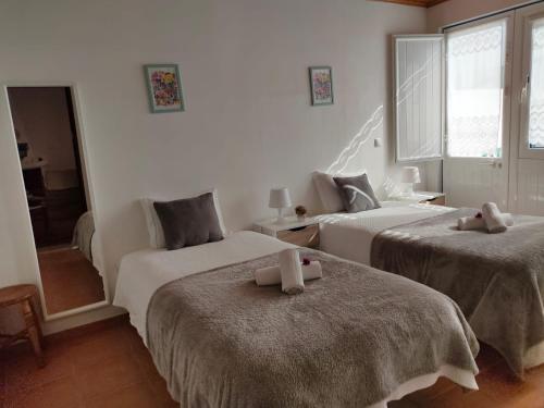 a bedroom with two beds with towels on them at Lodge & Hike Almograve in Almograve