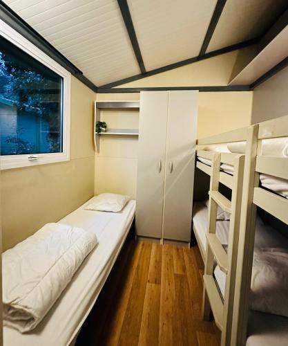 une petite chambre avec deux lits superposés et une fenêtre dans l'établissement Le Chalet de Louise 7 places, à Taradeau