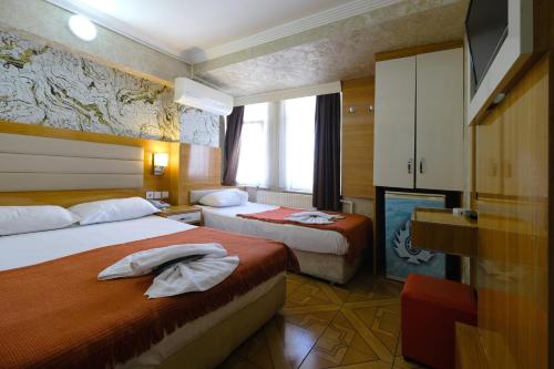 Habitación de hotel con 2 camas y TV en HOTELOZBEK, en Estambul