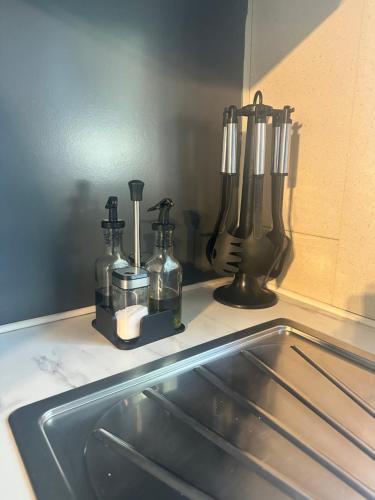 a kitchen sink with two bottles on a counter at Le Chalet de Louise 7 places in Taradeau