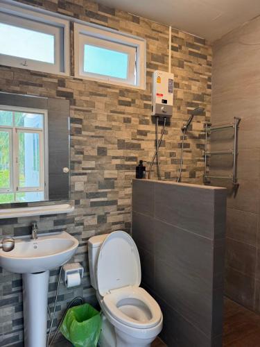 a bathroom with a toilet and a sink at San Peak Villa in Sam Roi Yot