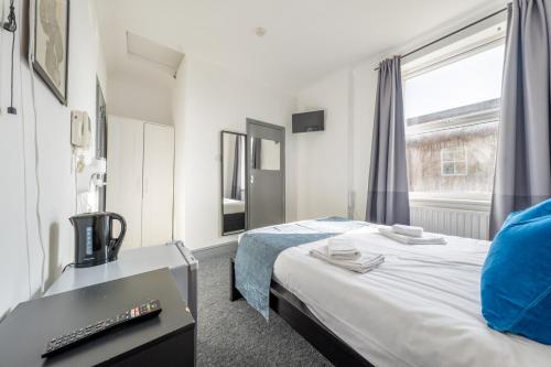 a hotel room with a bed and a window at Ryam Suites in London