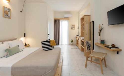 a bedroom with a bed and a tv on a wall at Capella Town, Skiathos in Skiathos Town