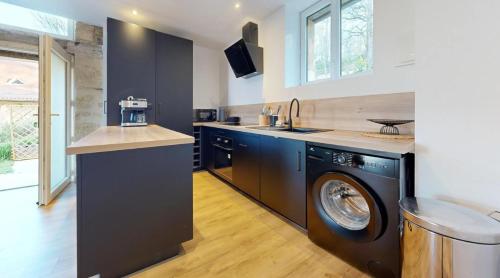 een keuken met een wasmachine en droger. bij Domaine de la Source in Castels