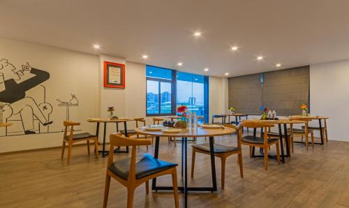 a restaurant with tables and chairs in a room at Treebo The Square in Ahmedabad