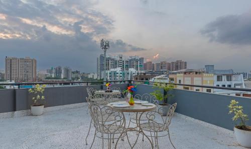 a table and chairs on a balcony with a city skyline at Treebo The Square in Ahmedabad