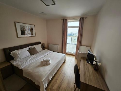 Schlafzimmer mit einem Bett und einem Fenster in der Unterkunft Restauracja & Hotel Polowczyk 