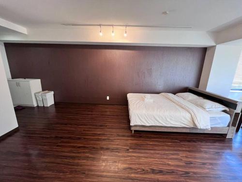 1 dormitorio con 1 cama y suelo de madera en 下寺3楼, en Osaka
