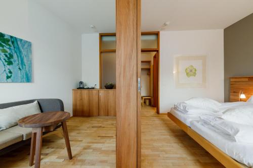 a bedroom with a bed and a table and a couch at Schloss Wartegg in Rorschacherberg