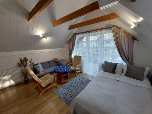 a bedroom with a bed and a living room at Willa Jack in Władysławowo