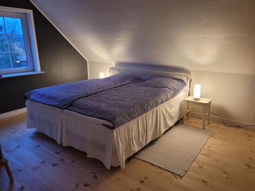 a bedroom with a bed and a window and two lights at Hestbjerggaard Apartment in Sejerslev