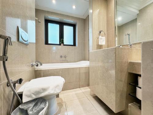 a bathroom with a tub and a toilet and a sink at Burj khalifa view 1BR Souk al Bahar Tajer Residences Mint avenue Downtown Golden Homes in Dubai