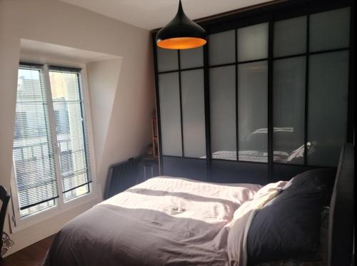 ein Schlafzimmer mit einem großen Bett und einem großen Fenster in der Unterkunft 40m2 flat - 10 min Parc des Princes / Trocadero in Paris