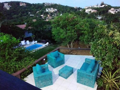 a patio with four blue chairs and a pool at Shanti Life in Búzios