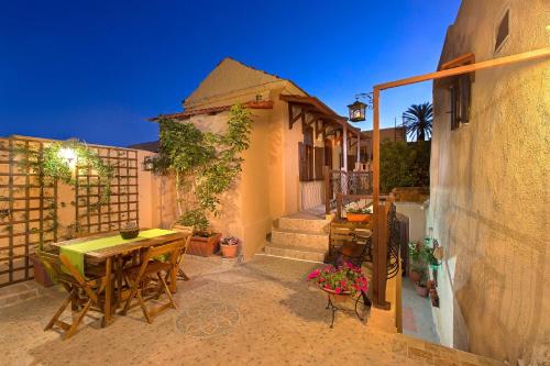a patio with a table and chairs and a building at Muses-Old Town in Rhodes Town
