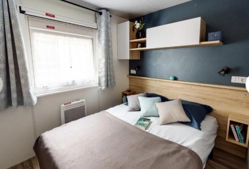 une chambre avec un grand lit et une fenêtre dans l'établissement Mobil-Home Camping 4* Landes Lac et Océan 6 à 8 p., à Gastes