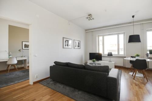 sala de estar con sofá y escritorio en Kotimaailma Apartments Kamppi - 1BR for 3 persons, en Helsinki