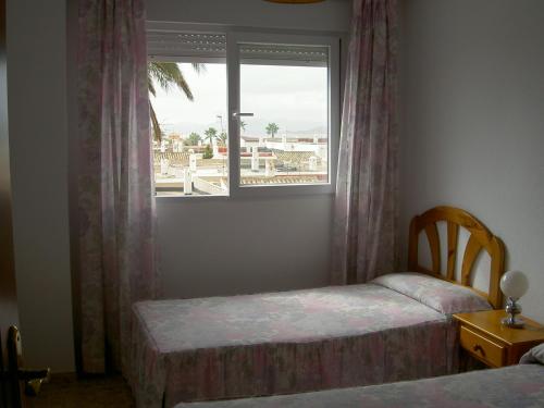 ラ・マンガ・デル・マール・メノールにあるBertur Isla Grosaのベッドルーム1室(ベッド2台、窓付)