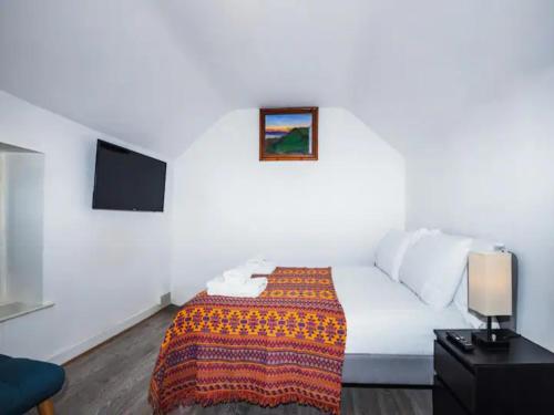 ein Hotelzimmer mit einem Bett und einem Flachbild-TV in der Unterkunft Pass the Keys Cosy Haven In Glastonbury: One Bedroom Apartment in Glastonbury