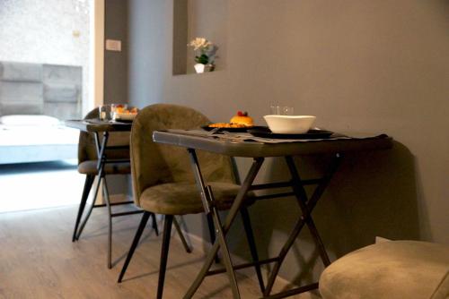 a table with two chairs and a bowl on top of it at Appartamento in pieno centro a Trento in Trento