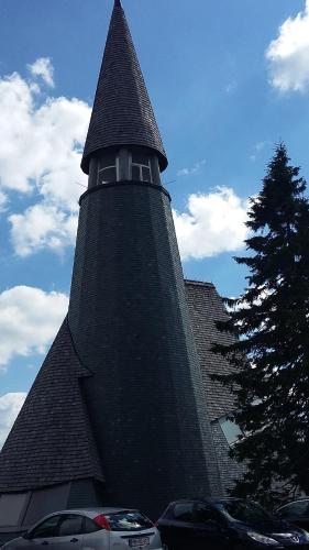 a large building with a steeple with cars parked in front at Apartma Rogla Gaber 110 in Zreče