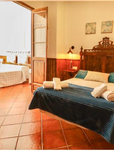 a bedroom with two beds and a mirror at SEÑORÍO de MARÍN piscina climatizada exterior in Arriate