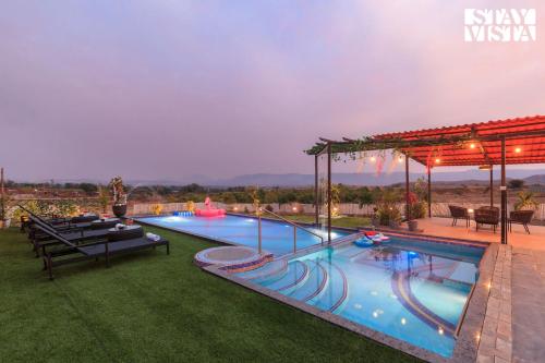 a swimming pool in a yard with a patioitures at StayVista at Mangifera Agro Estate with Pool, Wi-Fi in Pune