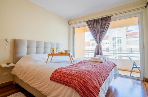 a bedroom with a bed with a table on it at Green Park Ajuda Apartment in Funchal