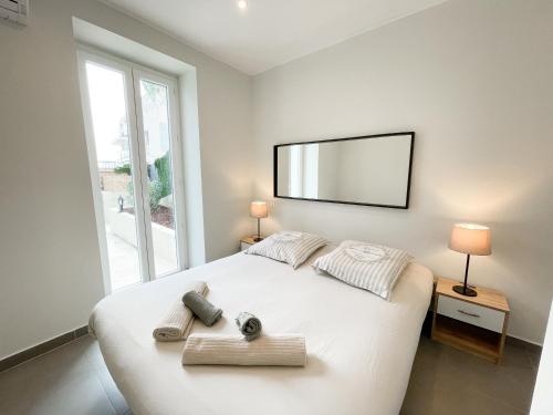 een slaapkamer met een groot wit bed en handdoeken bij Superdominante in Beausoleil