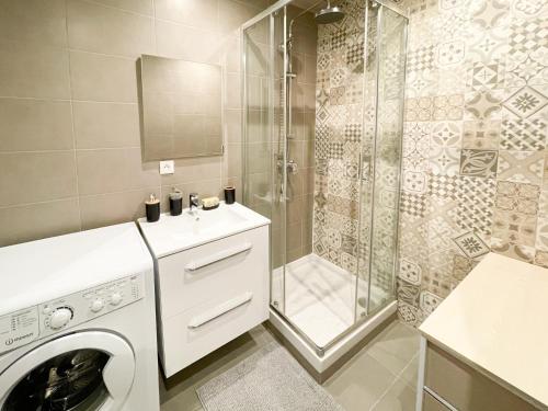 een badkamer met een wasmachine en een douche bij Superdominante in Beausoleil