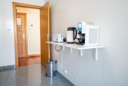 a kitchen with a coffee maker on a shelf at Green Park Ajuda Apartment in Funchal