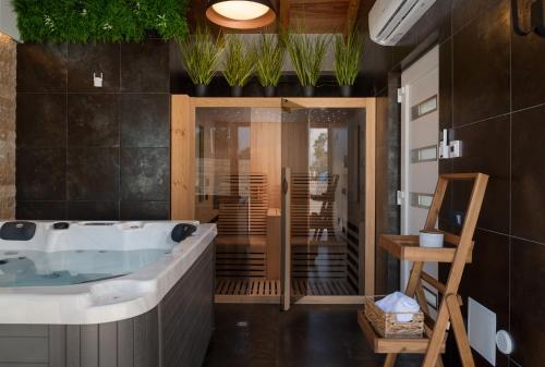 a bathroom with a tub and a table and chairs at Luxury Villa Salt & Stone with spa area in Nin in Nin