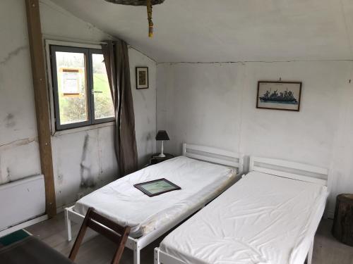 1 dormitorio con 2 camas y ventana en Les Chalets de Babeth et Cathy, 