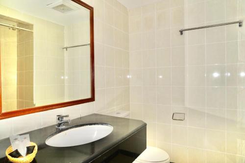 a bathroom with a sink and a mirror and a toilet at Stay 'd Kuningan in Jakarta