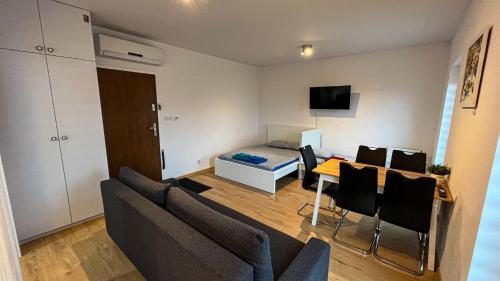 a living room with a couch and a table with chairs at Apartament Lublin Centrum "Ice Cat" FREE PARKING in Lublin
