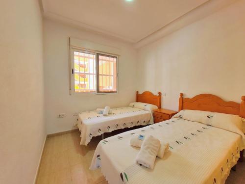 a bedroom with two beds and a window at Mar de Cristal Resort Apartamentos - Parking in Mar de Cristal