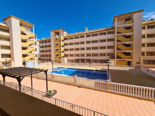 a swimming pool in front of two buildings at Mar de Cristal Resort Apartamentos - Parking in Mar de Cristal